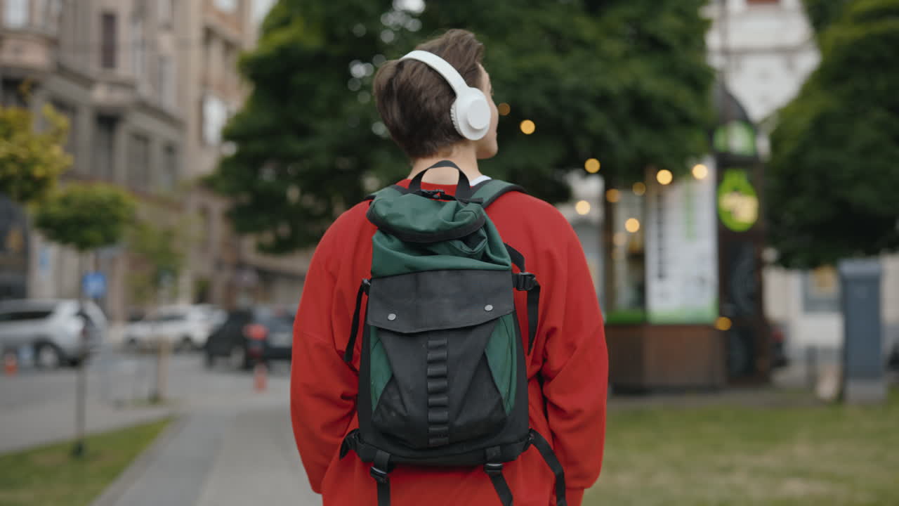 Man with headphones and backpack walking in the city