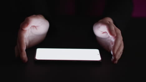 video of caucasian man's hand and smartphone with blank screen on black background
