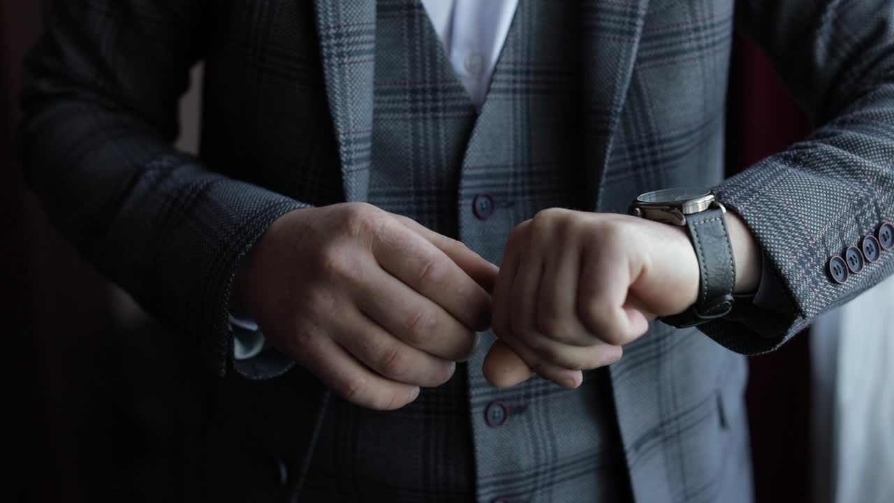un novio ajustando su reloj antes de su boda