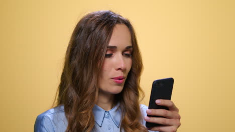 Business-woman-using-smartphone-on-yellow-background.-Woman-scrolling-phone