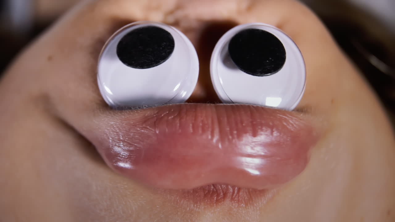 una cara de pato graciosa, fea y hilarante, obtenida poniendo ojos de google en la barbilla de una niña pequeña y disparando al revés