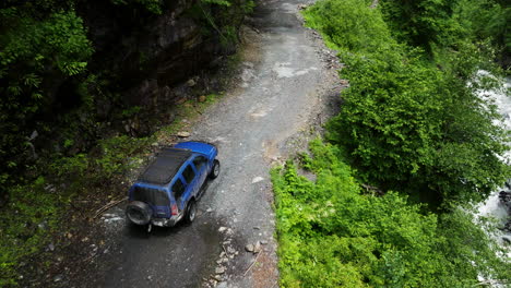 nissan xterra vehicle driving on the abano pass dirt road passing by in the valley in georgia