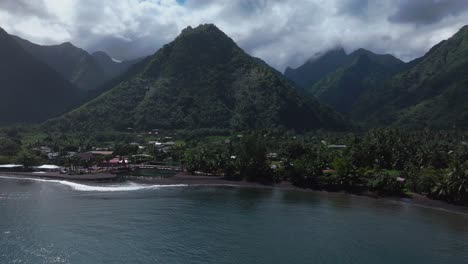 Paris-2024-Summer-Olympics-venue-pedestrian-bridge-Teahupoo-Tahiti-French-Polynesia-aerial-drone-sunny-cloudy-morning-mountain-valley-peaks-Point-Faremahora-shoreline-coastline-beach-forward-down