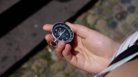 a young woman takes out a compass and holds it