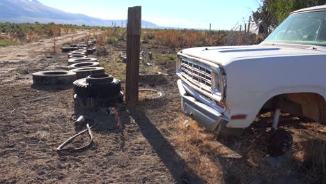 vieja camioneta abandonada en el desierto y neumáticos esparcidos