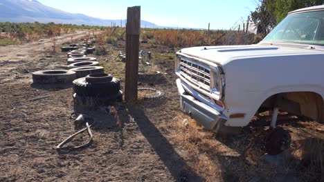 old abandoned pickup truck int he desert and tires strewn about