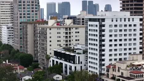 Aerial-view-rising-above-Wiltshire-corridor-high-rise-apartments-to-reveal-Century-city-Los-Angeles-skyline