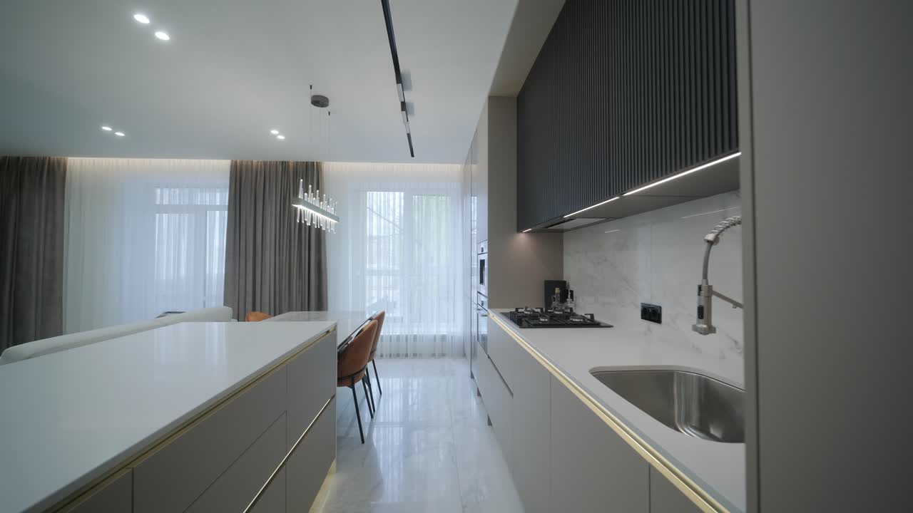 Interior de cozinha moderna com espaço de estar integrado.