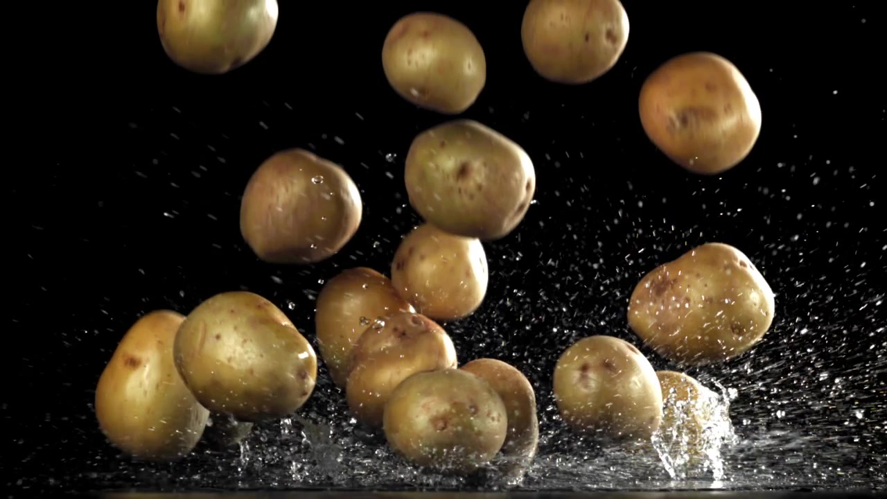 Patate fresche che cadono nell'acqua con schizzi al rallentatore