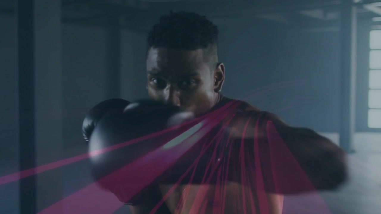 Vertical video: Starting guard, shirtless boxer punching combos in gym, black gloves pink trails