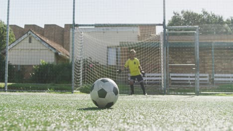 african american soccer kid in blue scoring in a sunny day