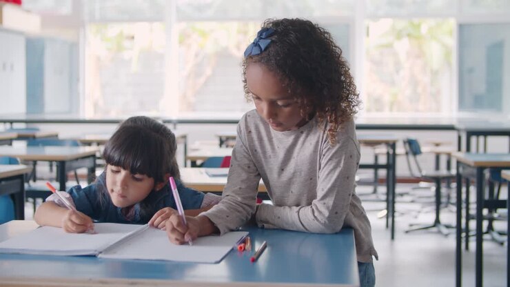 Alunos concentrados, afro-americanos e latinos, do ensino fundamental fazendo desenhos em um caderno