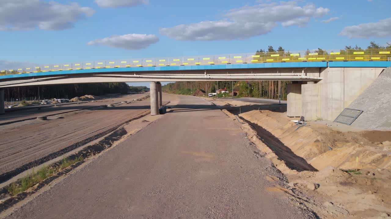 Aerial fly under the new established viaduct on new highway interchange near the city