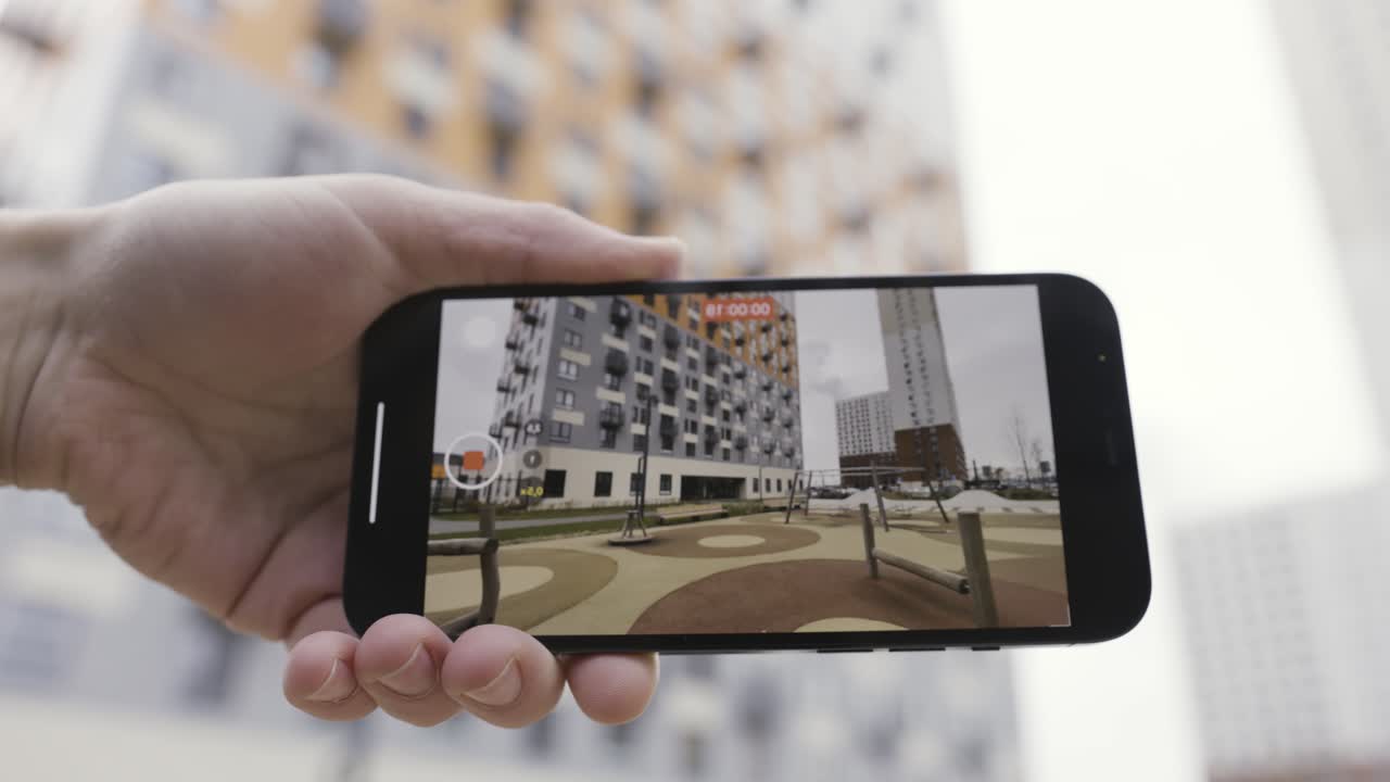 teléfono inteligente que muestra una vista de un complejo de apartamentos de la ciudad con un patio de recreo
