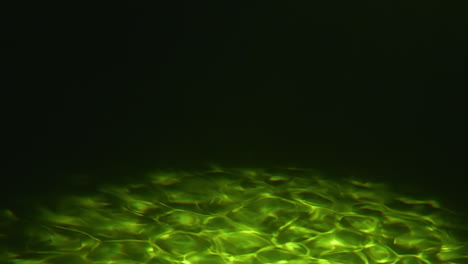 fondo marino verde y oscuro bajo el agua con cáusticos en el fondo del océano