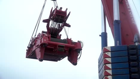 large red crane lifting heavy equipment