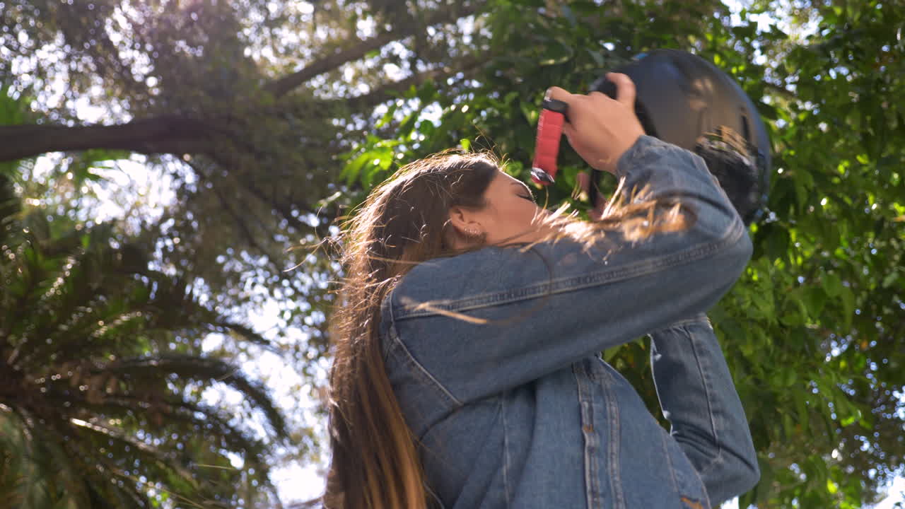 헬멧을 쓰고 도시에서 전기 스쿠터를 가진 젊은 여자