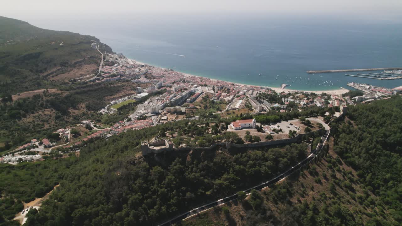 vista de arriba hacia abajo de la costa natural de sesimbra y el castillo en la cima de una colina, un paisaje fascinante - portugal