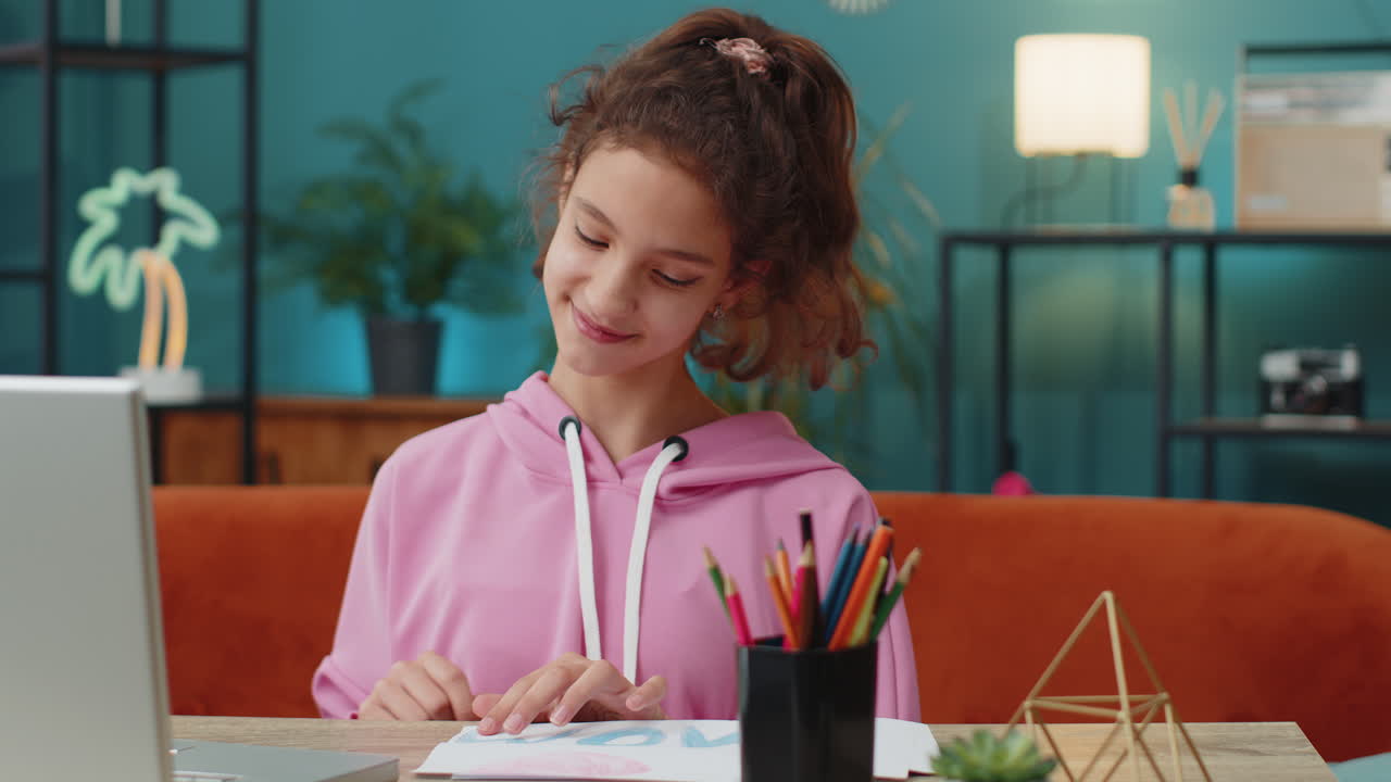 School girl drawing colorful picture i love mom with pencils on white paper greeting card for mother