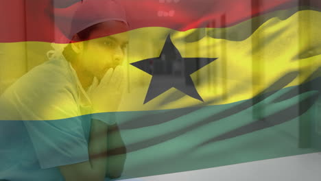 composición digital de la bandera de ghana ondeando contra un trabajador de salud caucásico estresado en el hospital