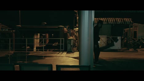 person standing under pillar at night in urban area