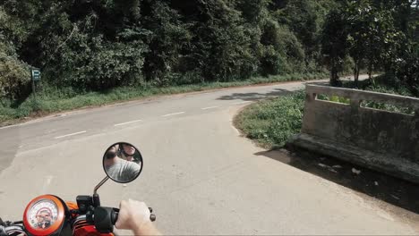 couple riding a moped through beautiful mountainous road in thailand