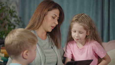 curious children bother busy mommy working on modern tablet