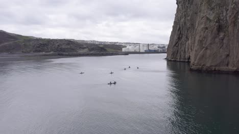 Menschen-In-Kajaks-Neben-Großen-Felsklippen-Der-Insel-Im-Atlantik,-Aus-Der-Luft