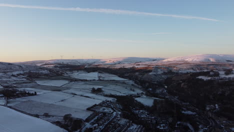 Tiro-De-Drone-Del-Sol-De-Invierno-Brillando-En-Las-Colinas-Nevadas-En-Húmedo-Yorkshire