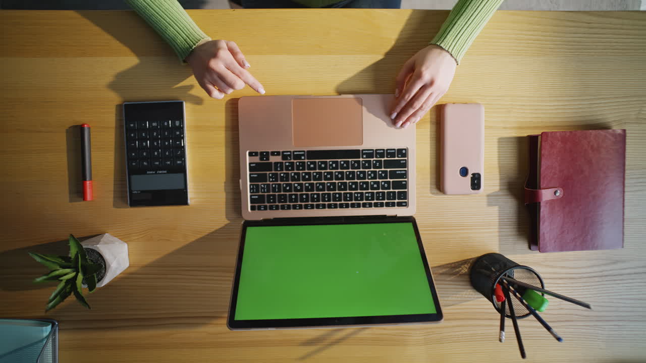 Lady hands touching chromakey laptop at wooden office table closeup top view