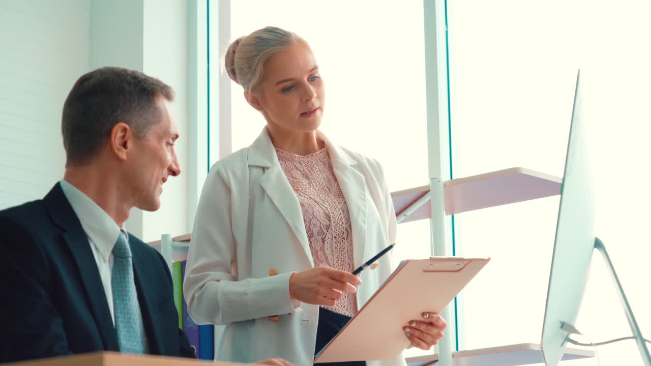 Zwei Geschäftsleute besprechen im Büro die Projektstrategie.