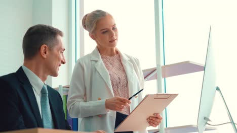 two business people talk project strategy at office