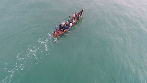 Aerial-shot-of-a-local-fishermen-rowing-their-canoe-early-morning