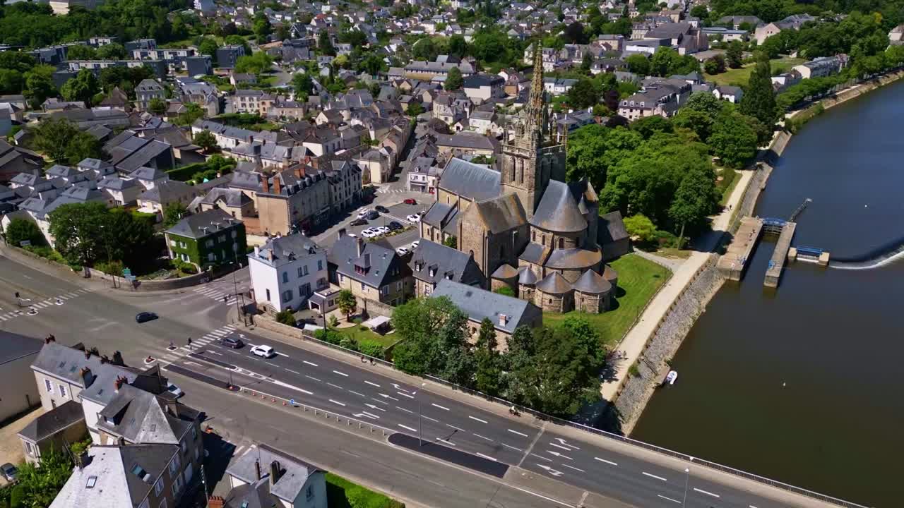 Hyperlapse drone circling Notre-Dame d’Avesnières with views of Mayenne River and surrounding houses in Laval, France