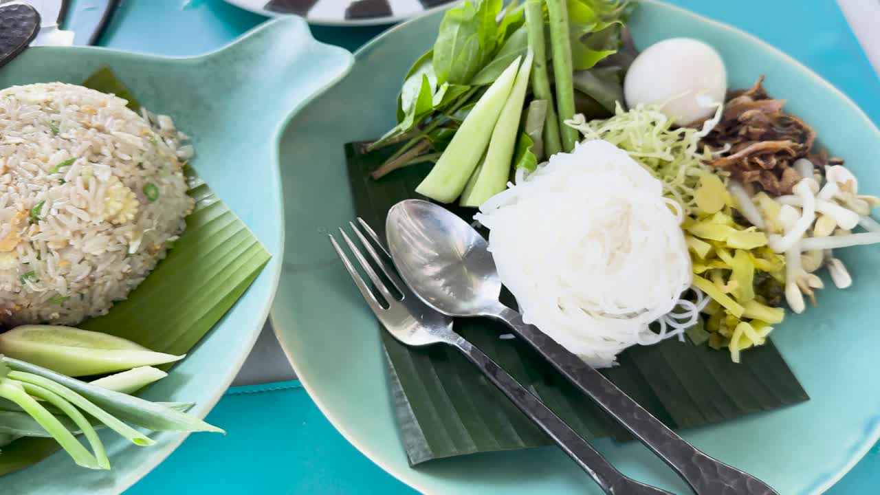 A vibrant display of Thai crab fried rice and Kanom Jeen Nam Ya Pu, showcasing fresh ingredients and colorful presentation