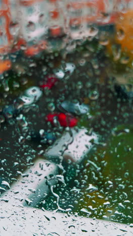 Yard of the residential area in the city from top floor. Rain dripping by the glass. Close up. Vertical video