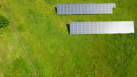 Vista-Aérea-De-Arriba-Hacia-Abajo-De-Los-Campos-De-Paneles-Solares-Por-Naturaleza-Verde