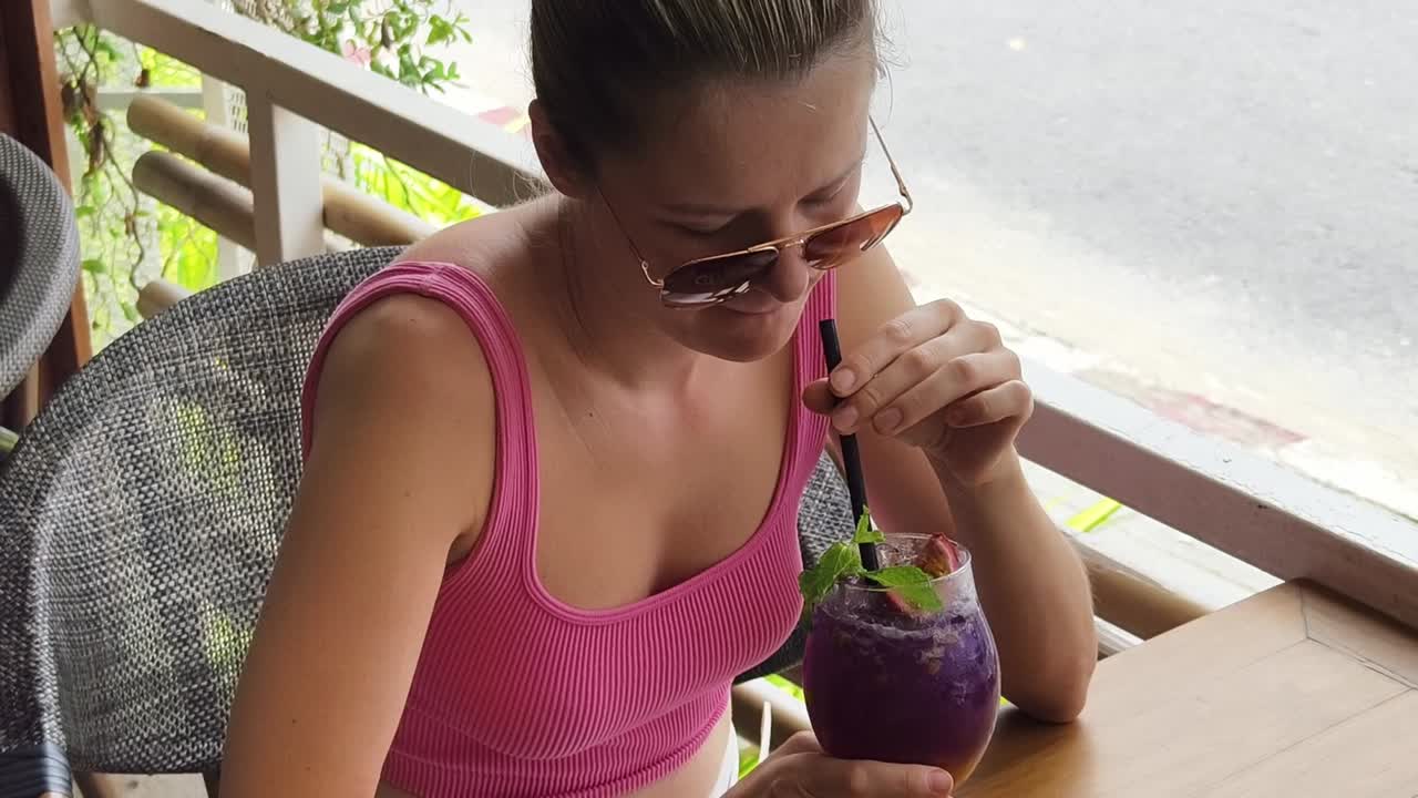 야외 에서 보라색 음료 를 마시는 여자