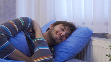 un joven tendido en la cama pensando felizmente.