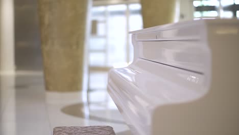 white piano with closed keyboard in a bright luxury interior