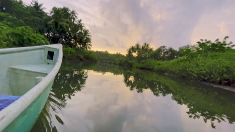 Proa-De-Kayak-En-El-Río-Saleri-Durante-Una-Colorida-Y-Vibrante-Puesta-De-Sol,-Goa-India-4k