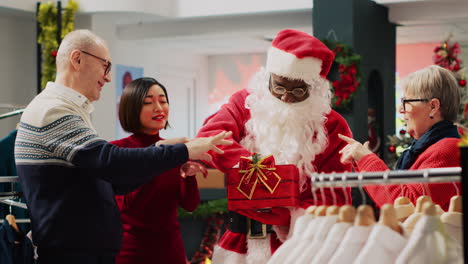 customers participating in christmas raffle hold by employee dressed as santa claus in clothing store. asian woman excited after winning winter holiday season promotional fashion shop contest