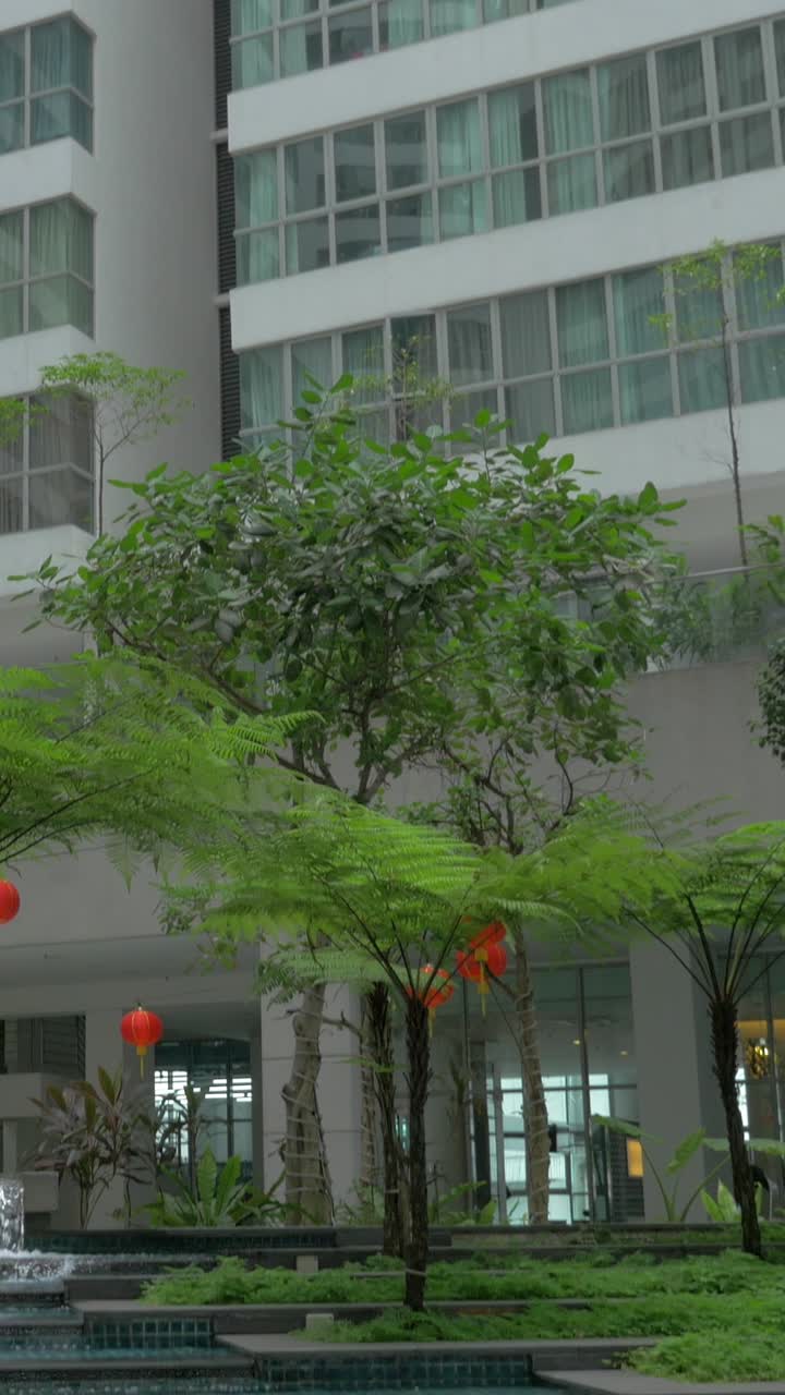 Edifício Moderno de Grande Altura com Jardim Exuberante e Elemento Aquático