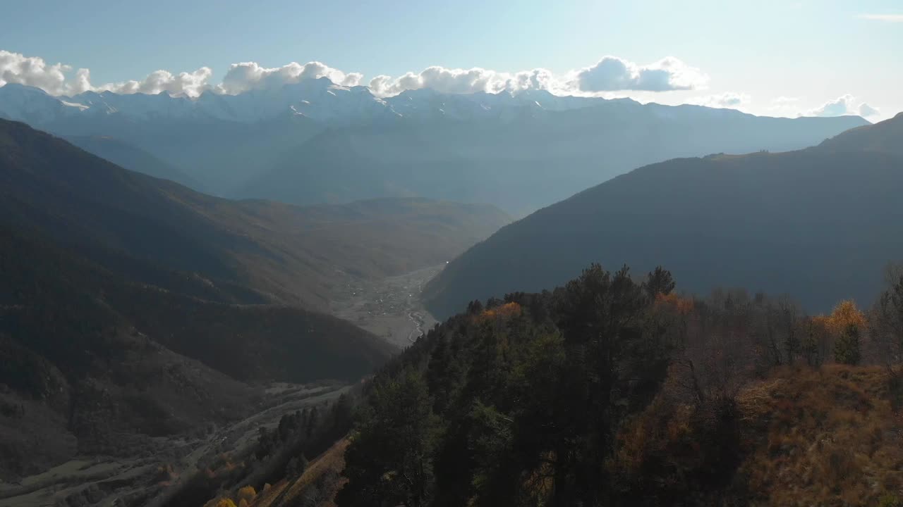 clip aéreo de avance lento de un valle georgiano y muchas montañas, durante el otoño