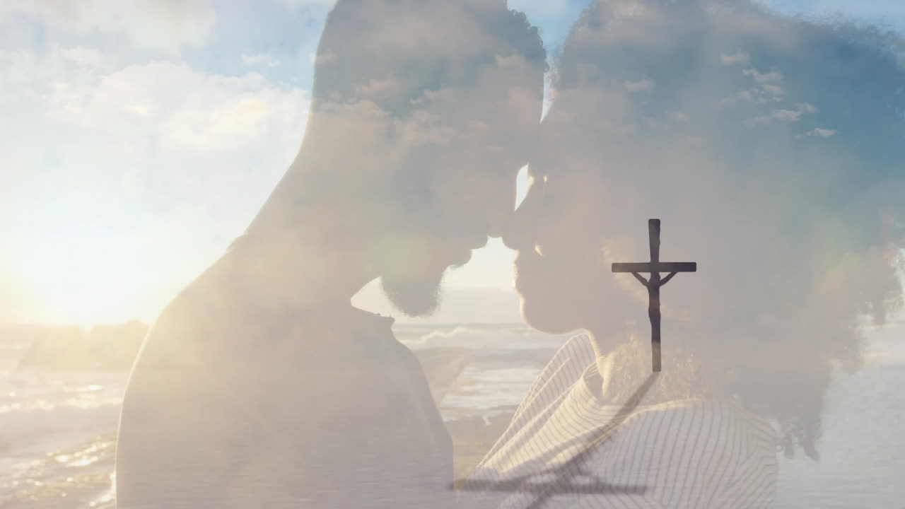 Embracing couple on beach with cross shadow overlay in sunset animation