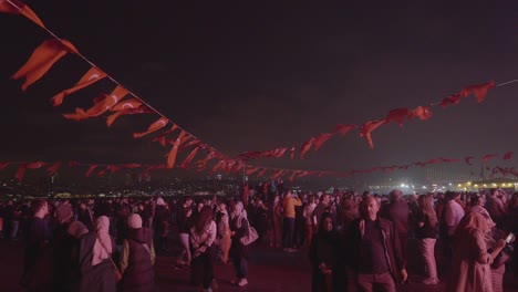 large crowd celebrates at night in istanbul with turkish flags