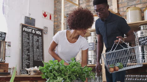 young couple buying fresh fruit and vegetables in sustainable plastic free grocery store