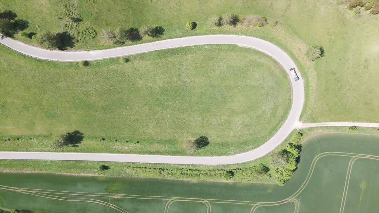 폴란드의 굴곡진 도로에서 나무 들보를 운반하는 트럭, 공중 하향식