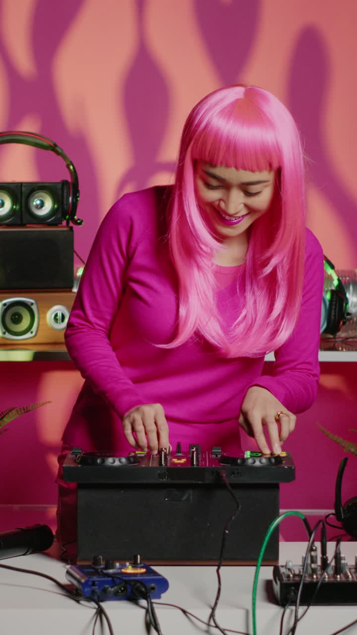 Video verticale: musicista asiatico in piedi alla console da DJ che mixa suoni elettronici