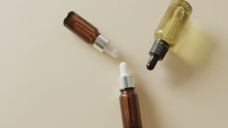 Close-up-of-three-glass-bottles-with-pumps-with-copy-space-on-beige-background-with-copy-space